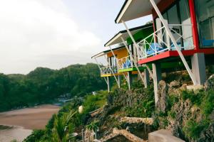 a building on top of a hill with a beach at Baron Lighthouse Cottage & Eatery in Baron