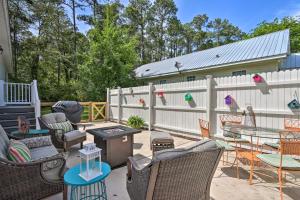 a patio with chairs and tables and a fence at Charming Bluffton Escape with Patio and Gas Grill in Bluffton