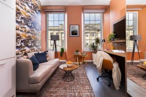 a living room with a couch and a desk at Heeton Concept Aparthotel Edinburgh Queen Street in Edinburgh