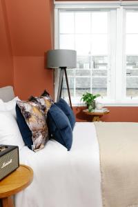 爱丁堡Heeton Concept Aparthotel Edinburgh Queen Street的一张带蓝色枕头的床和窗户