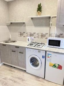 a kitchen with a washing machine and a sink at Вип 1комн Айтиева 70 in Uralsk +7 photos