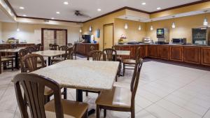 a restaurant with tables and chairs and a kitchen at Best Western Geneseo Inn in Geneseo