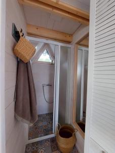 a bathroom with a shower with a towel on the wall at Vila Preiloja - Žvejo namelis in Neringa
