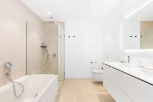 a bathroom with a tub and a sink and a toilet at New Luxury Apartment First Sea Line in Palm-mar