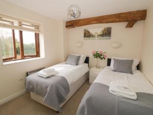 1 dormitorio con 2 camas y ventana en The Wheat House, en Stratford-upon-Avon