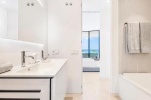 bagno bianco con lavandino e vista sull'oceano di New Luxury Apartment First Sea Line a Palm-Mar