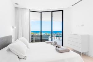 New Luxury Apartment First Line Sea View في بالم مار: غرفة نوم مع سرير وإطلالة على المحيط