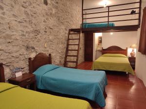 1 dormitorio con 2 literas y pared de piedra en El Encuentro, en Cuetzalán del Progreso