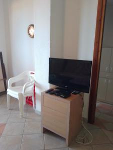 un téléviseur à écran plat posé sur un support en bois dans l'établissement Terrazza sul mare, à Villaputzu