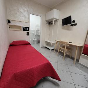 Schlafzimmer mit einem roten Bett und einem Schreibtisch in der Unterkunft HomeFamily in Lido di Ostia