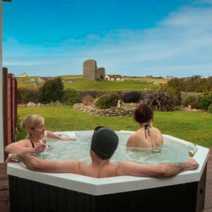 un grupo de personas en una bañera de hidromasaje con copas de vino en Luxury Lodges in Doolin Village with Hot Tubs, en Doolin