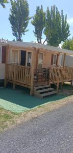 a mobile home with a porch and a deck at Mobile home à louer 8 personnes in Valras-Plage
