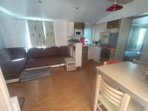 sala de estar con sofá y cocina en Mobile home à louer 8 personnes en Valras-Plage