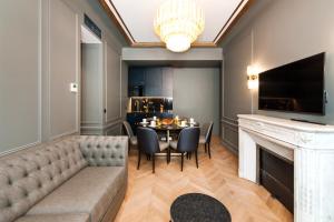 Pick A Flat's Champs Elysees Apartments - Rue Lincoln في باريس: غرفة طعام مع أريكة وطاولة مع كراسي