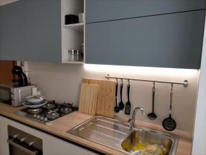 um balcão de cozinha com um lavatório e um fogão em appartamento incantevole a due passi dal mare a Viserbella vicino fiera Rimini em Rimini