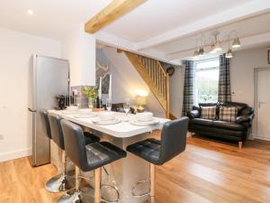 een keuken en eetkamer met een tafel en stoelen bij Bluebell Cottage in Birch Vale