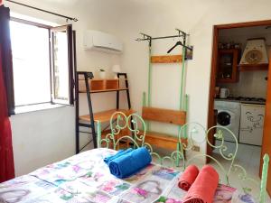 パレルモにあるGrazioso appartamento nel cuore di Palermoのベッド1台付きの部屋、窓付きのキッチンが備わる客室です。