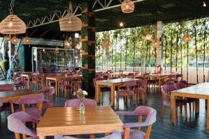 a restaurant with wooden tables and chairs and trees at Rancho Macloy Hotel Spa & Social Events in Yautepec de Zaragoza