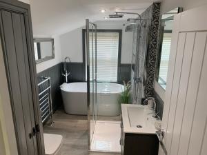 a bathroom with a tub and a toilet and a sink at Luxury House, central Stamford with parking in Stamford