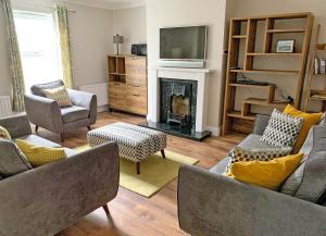 a living room with couches and a fireplace at Churchmount Holiday Home Roundwood in Wicklow