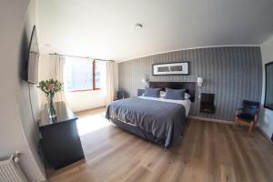 a bedroom with a large bed and a wooden floor at Hotel RP in Temuco