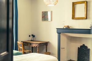 Zimmer mit einem Kamin und einem Tisch mit einem Spiegel in der Unterkunft Maison Léonard du Ventoux in Sault-de-Vaucluse