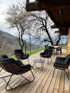 a group of chairs and tables on a wooden deck at Maison de montagne Alpes du sud/station Les Orres in Les Orres