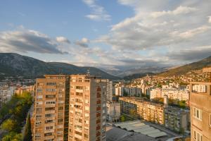 uitzicht op een stad met gebouwen en bergen bij HelloSky Apartment in Mostar