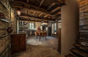 Il comprend une cuisine avec des plafonds en bois, une table et des chaises. dans l'établissement il Friscello, à Loro Ciuffenna