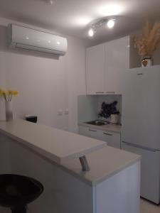 a kitchen with white cabinets and a white counter top at Apartman Sky in Pula