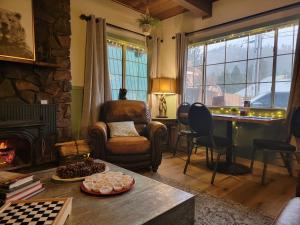 a living room with a stone fireplace and a table at Cinnamon Bear Inn in Mammoth Lakes