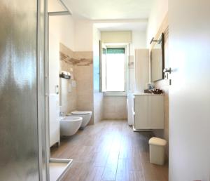 a bathroom with two toilets and two sinks and a shower at Infinity Luxury in Lezzeno