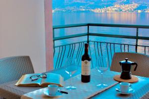 a bottle of wine sitting on a table with glasses at Infinity Luxury in Lezzeno
