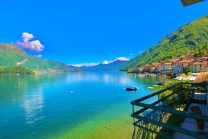 vista su una cassa d'acqua con case e montagne di Infinity Luxury a Lezzeno