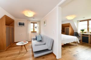 a bedroom with a bed and a chair and a table at Hotel Montfort-Schlössle in Lindau