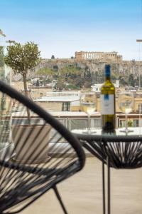 uma garrafa de vinho sentada em cima de uma cadeira em Arcade Hotel Athens em Atenas
