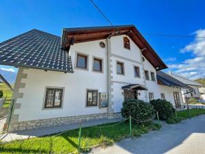 una casa blanca con techo marrón en Zotlar House, en Bohinj