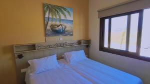 a bedroom with a bed and a window with a palm tree at STAY Chrystallia Holiday Villa in Anarita +83 photos