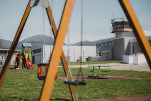un parco giochi con altalene di fronte ad un aeroporto di Airport Inn Preturo Affittacamere a San Vittorino
