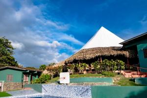 um resort com um telhado de palha e uma pirâmide branca em La Pintada Inn em La Pintada