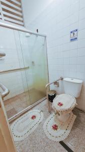 uma casa de banho com uma cabina de duche em vidro e um WC. em Aldeia Hostel em Manaus