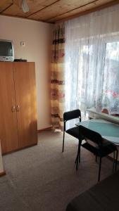 a living room with a table and a tv and a cabinet at U Tosi in Czorsztyn
