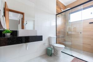 La salle de bains est pourvue de toilettes et d'une douche en verre. dans l'établissement Apartamento região central de foz do Iguaçu, à Foz do Iguaçu