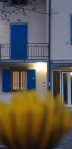 uma imagem desfocada de um edifício com portas azuis e um objecto amarelo em B&B Des Artistes em Borzano