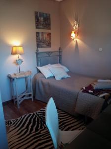 1 dormitorio con 1 cama y 1 mesa con lámpara en patricia, en Villaviciosa de Odón