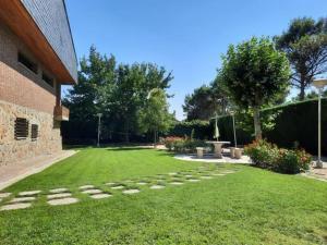 einen Garten mit einem Backsteingebäude und einem Rasenplatz in der Unterkunft patricia in Villaviciosa de Odón + 6 Fotos