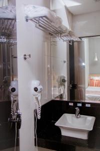 a bathroom with a sink and a mirror at Grande Hotel Ipatinga in Ipatinga