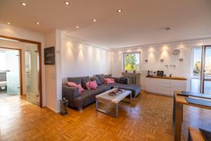 ein Wohnzimmer mit Sofa und Tisch in der Unterkunft Ferienwohnung Seeblick mit Blick auf die Alpen in Wasserburg