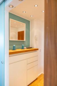 ein Badezimmer mit Waschbecken und Spiegel in der Unterkunft Ferienwohnung Seeblick mit Blick auf die Alpen in Wasserburg + 21 Fotos