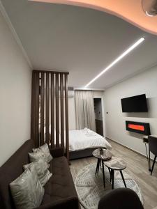 sala de estar con sofá y cama en COZY DOWNTOWN APARTMENT, en Xanthi